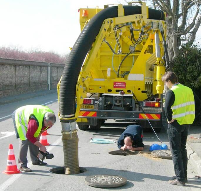 team cleaning catch basin using truck